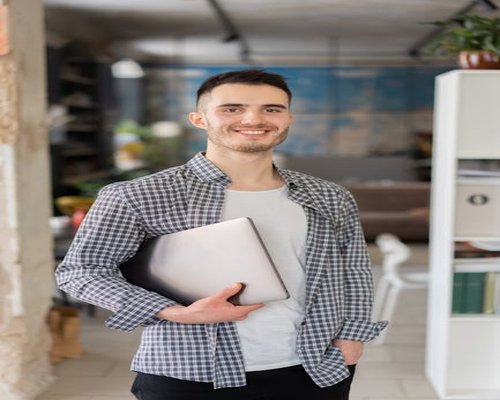 young professional man smiling in casual office attire